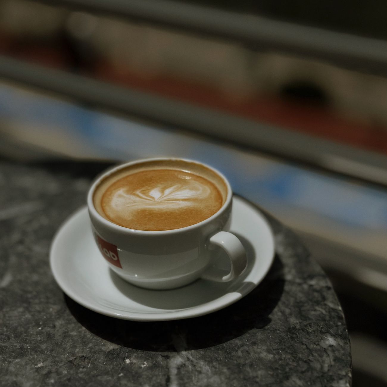 Flat white with latte art on a dark marble table