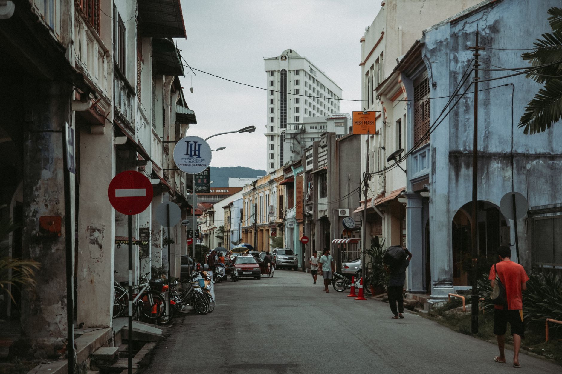 George Town street at dusk lined with shophouses and hanging signboards